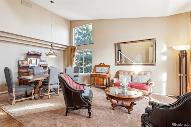 sitting room featuring visible vents, high vaulted ceiling, and baseboards