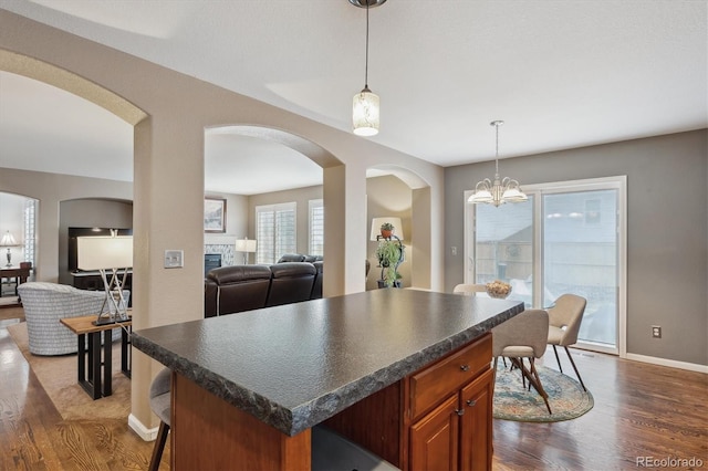 kitchen featuring dark countertops, open floor plan, and dark wood finished floors