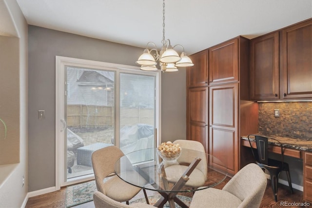 dining space featuring baseboards, an inviting chandelier, and dark wood-style flooring