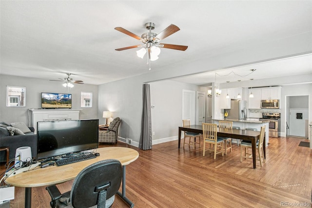 office with light wood-type flooring and ceiling fan