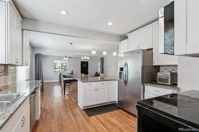 kitchen with white cabinetry, light hardwood / wood-style flooring, light stone counters, and stainless steel appliances