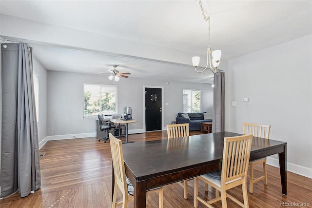 dining area with ceiling fan with notable chandelier and hardwood / wood-style flooring