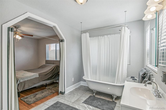 bathroom with a healthy amount of sunlight, ceiling fan, a bath, and hardwood / wood-style flooring