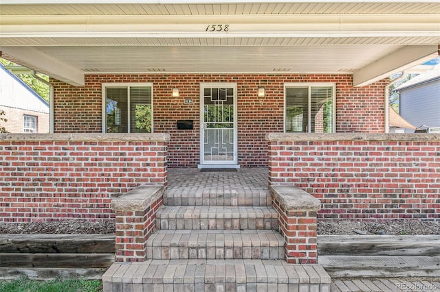 view of exterior entry featuring covered porch