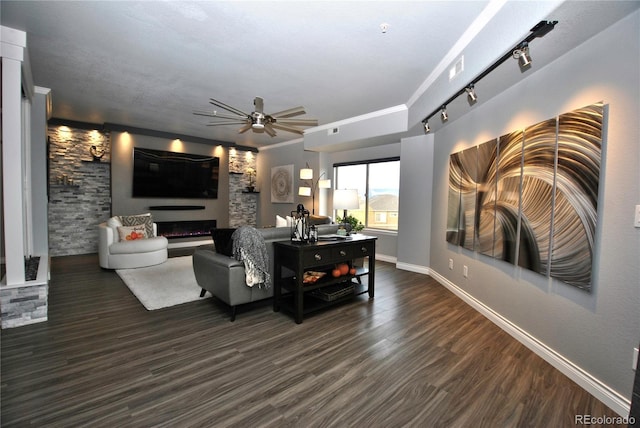 living room featuring dark wood-type flooring, ceiling fan, ornamental molding, and rail lighting