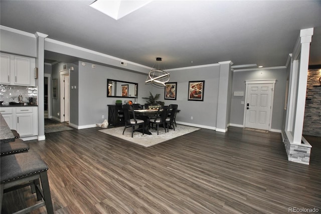 dining area with ornamental molding, dark hardwood / wood-style floors, and a skylight