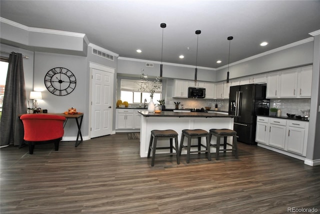 kitchen featuring dark wood-type flooring, hanging light fixtures, tasteful backsplash, black appliances, and white cabinets