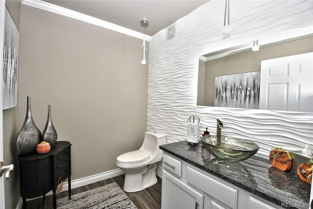 bathroom with vanity, ornamental molding, hardwood / wood-style floors, and toilet