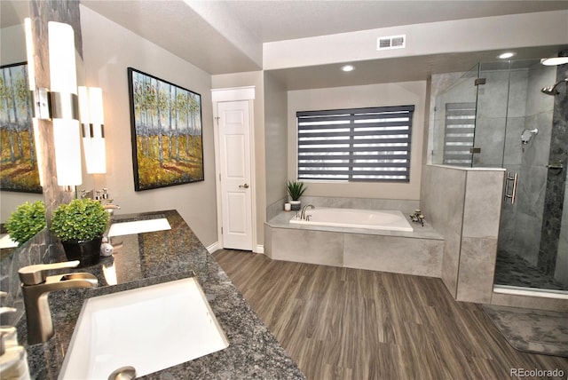 bathroom featuring vanity, separate shower and tub, and hardwood / wood-style floors