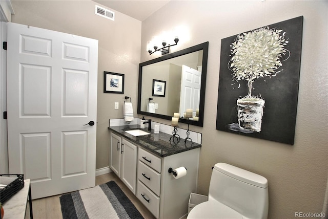 bathroom featuring vanity, toilet, and hardwood / wood-style floors