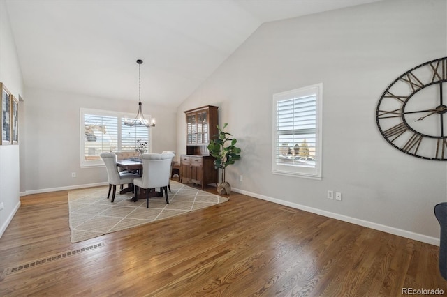 dining area with hardwood / wood-style floors, a notable chandelier, and a wealth of natural light