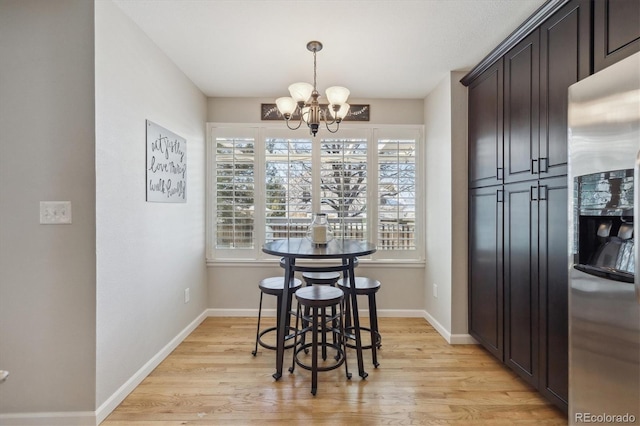 dining room featuring light wood-type flooring and an inviting chandelier