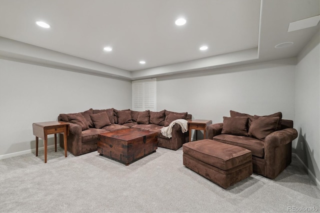 carpeted living room featuring a tray ceiling