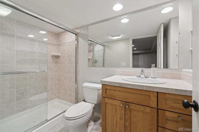 bathroom featuring vanity, a shower with shower door, and toilet