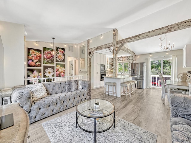 living room with lofted ceiling with beams, light wood-type flooring, and a chandelier