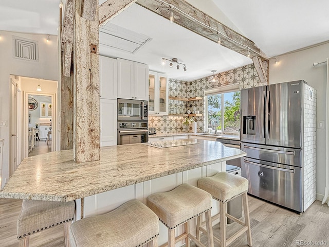 kitchen featuring white cabinets, appliances with stainless steel finishes, lofted ceiling, and sink