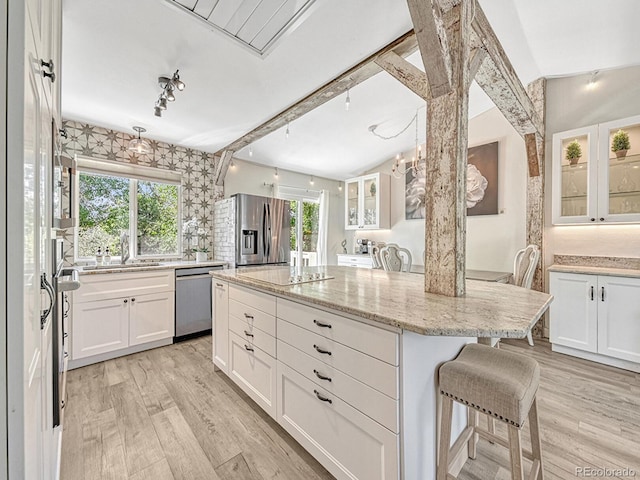 kitchen featuring white cabinetry, a center island, a healthy amount of sunlight, and appliances with stainless steel finishes