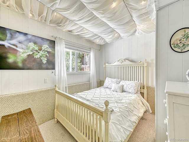 bedroom featuring carpet flooring and wood walls