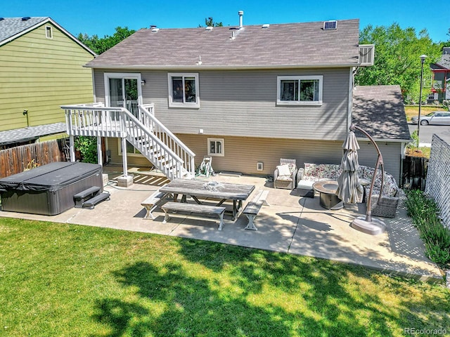 back of property with a lawn, a patio, and a hot tub