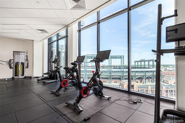 exercise room with expansive windows and a water view