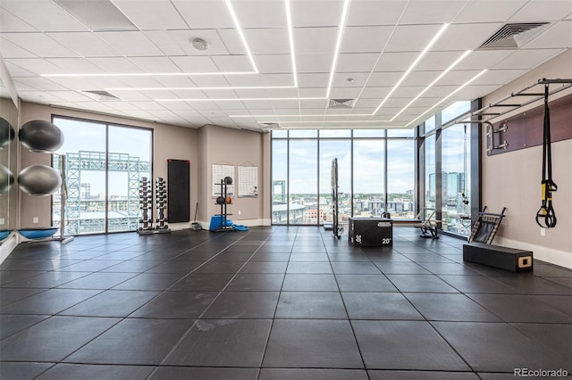 workout area with floor to ceiling windows and a drop ceiling