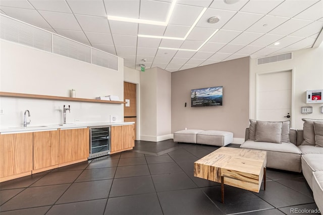 tiled living room featuring sink and wine cooler