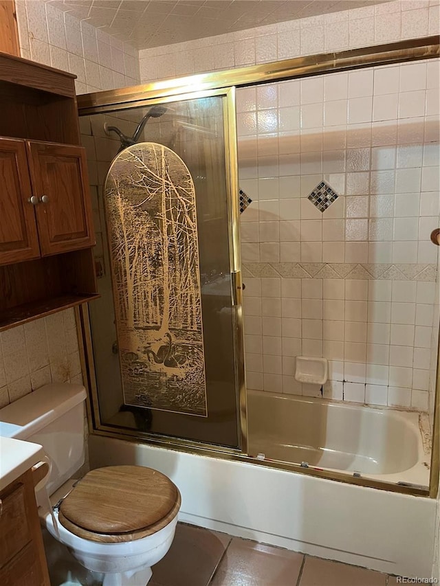 full bathroom with toilet, tile patterned flooring, vanity, and bath / shower combo with glass door