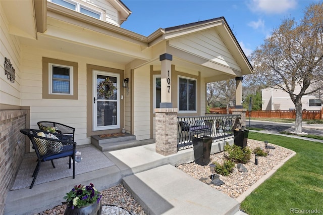 property entrance with a porch and fence