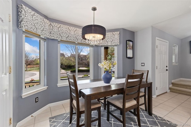dining space with baseboards, a notable chandelier, and light tile patterned floors