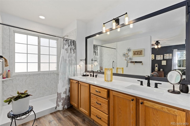 full bath featuring double vanity, a ceiling fan, wood finished floors, a sink, and a shower with shower curtain