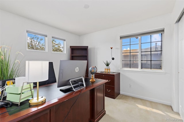 office featuring baseboards and light carpet