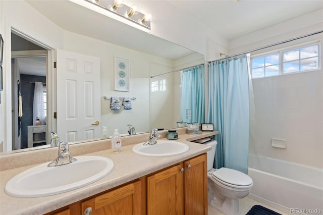 full bathroom with double vanity, toilet, a sink, and shower / bath combo