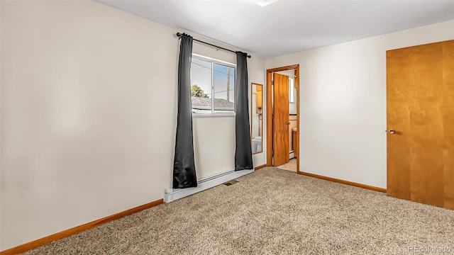 carpeted spare room with a baseboard radiator