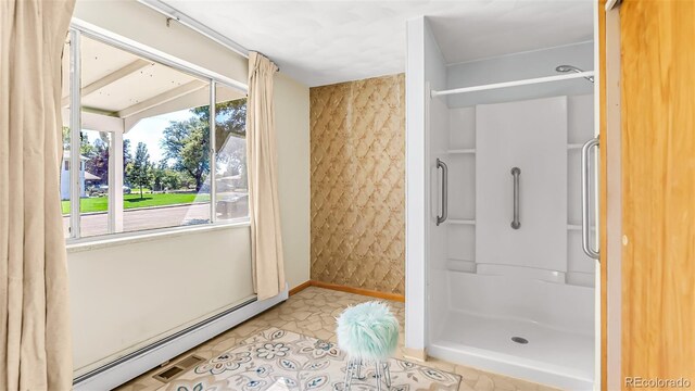 bathroom with a shower, baseboard heating, and tile patterned floors