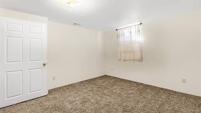 empty room with a textured ceiling and carpet