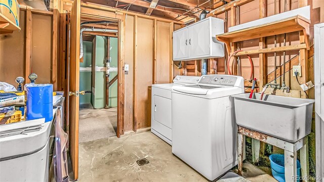 laundry room featuring sink, washer and dryer, and cabinets