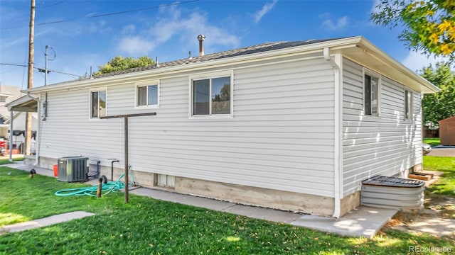 view of home's exterior with central air condition unit and a yard