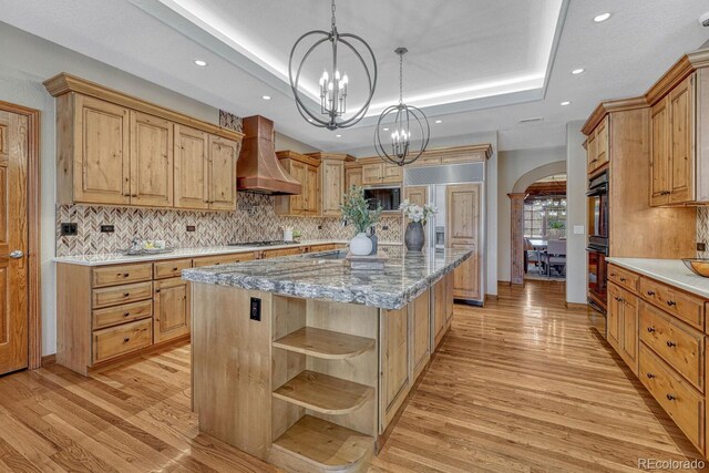 14581 E Oberlin Pl, Aurora, CO 80014 - kitchen with custom range hood, open shelves, a raised ceiling, arched walkways, and recessed lighting