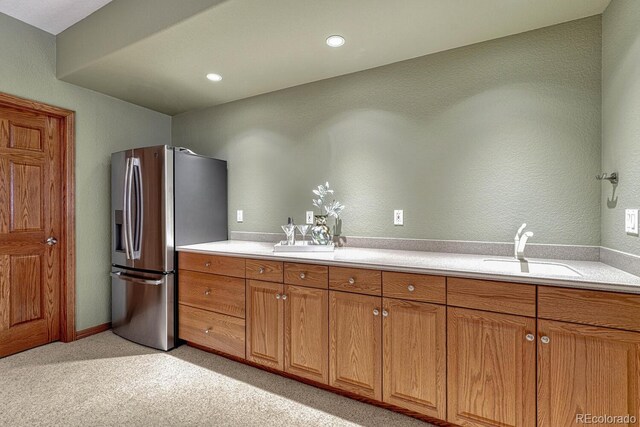 14581 E Oberlin Pl, Aurora, CO 80014 - kitchen with stainless steel fridge with ice dispenser, a sink, brown cabinetry, light countertops, and light colored carpet