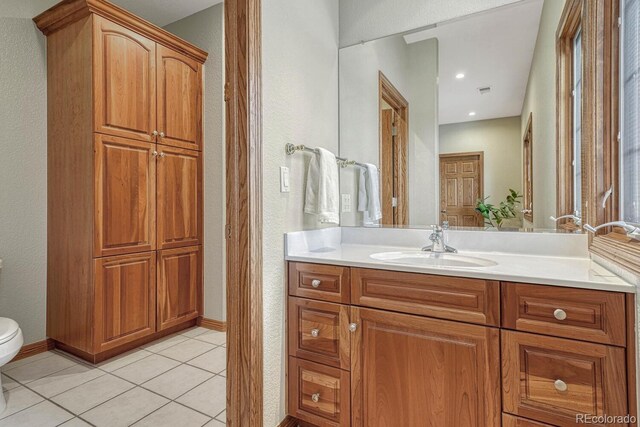 14581 E Oberlin Pl, Aurora, CO 80014 - bathroom with vanity, toilet, tile patterned flooring, a textured wall, and baseboards