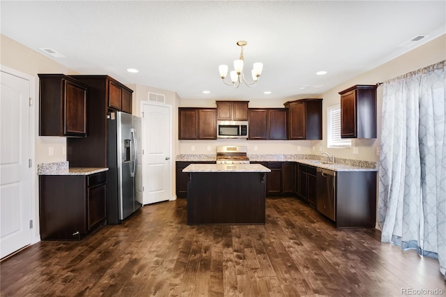 10733 Calista Way, Fountain, CO 80817 - kitchen with appliances with stainless steel finishes, a chandelier, a kitchen island, a sink, and dark wood-style flooring