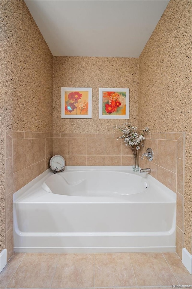 bathroom featuring a washtub, tile walls, and tile patterned flooring