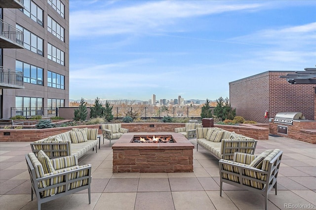 view of patio featuring exterior kitchen, grilling area, and an outdoor living space with a fire pit