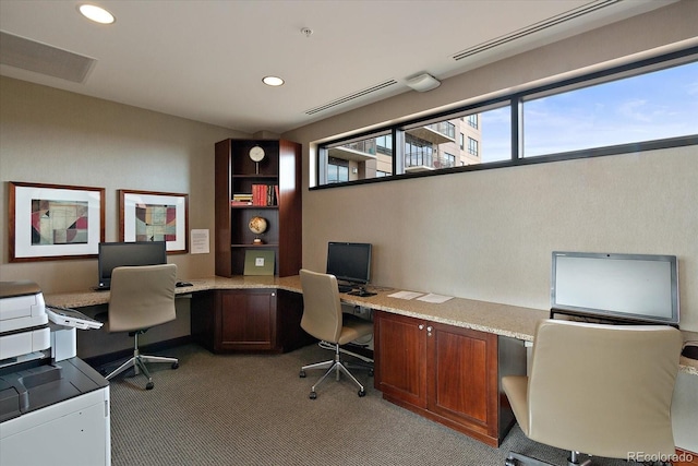 carpeted home office featuring built in desk