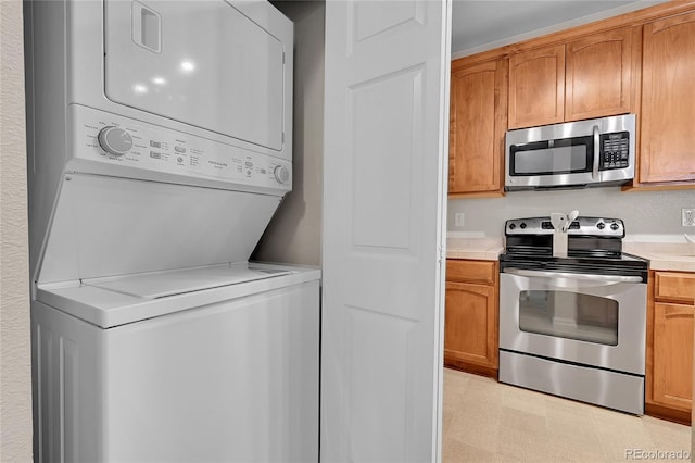 3852 S Dallas St Unit 8-102, Aurora, CO 80014 - laundry area featuring stacked washer and clothes dryer and light flooring