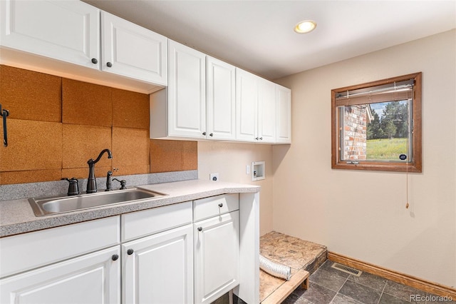 washroom with hookup for an electric dryer, washer hookup, cabinets, and sink