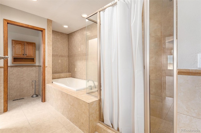 bathroom featuring tile patterned flooring, shower with separate bathtub, and tile walls