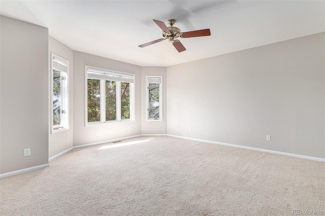 spare room with ceiling fan and light colored carpet