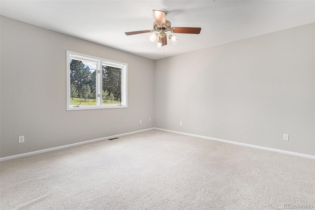 carpeted spare room featuring ceiling fan