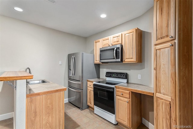 kitchen featuring tile countertops, sink, light tile patterned floors, and stainless steel appliances